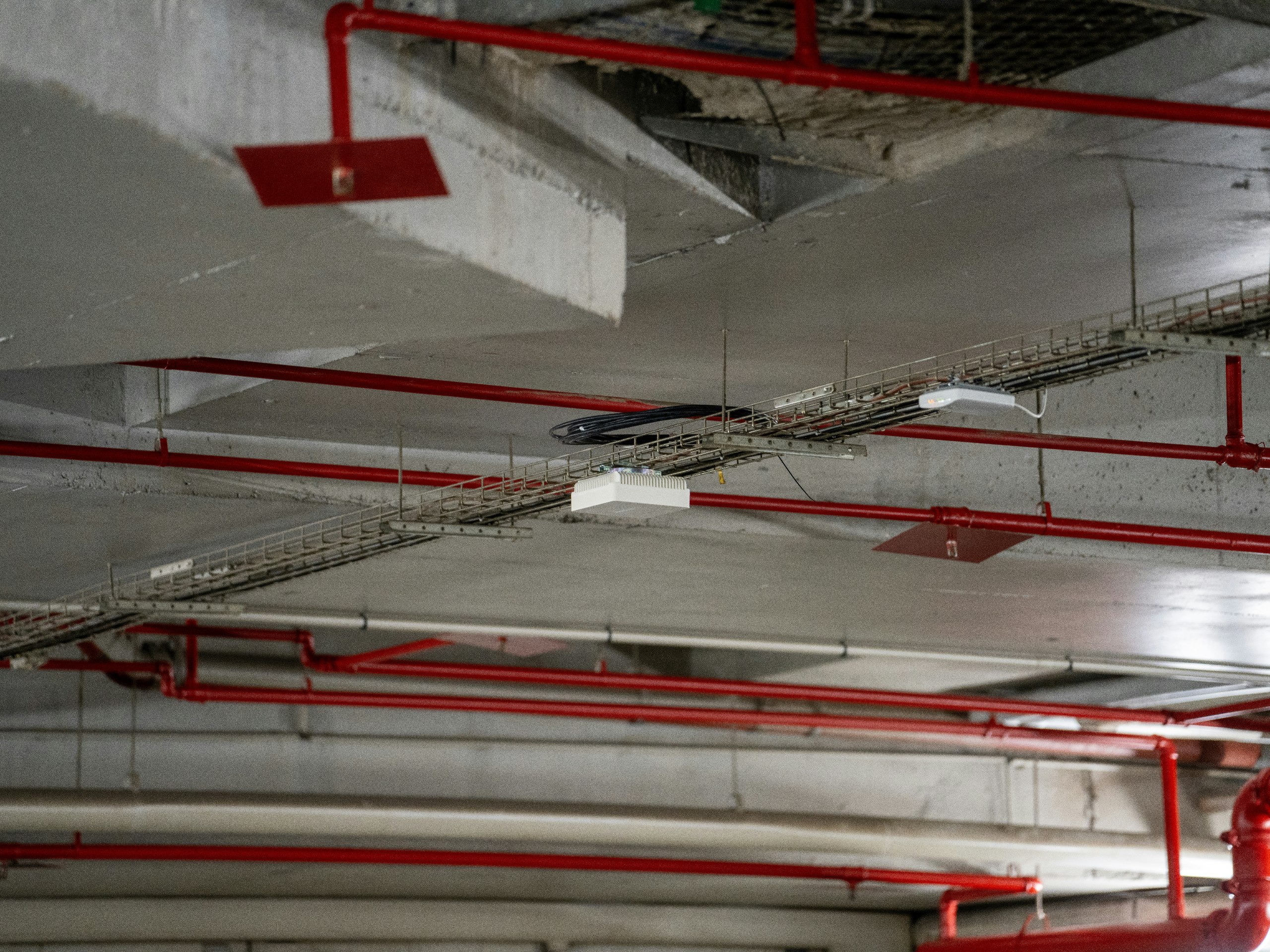 Rote Brandschutzleitungen und technische Installationen unter einer Betondecke